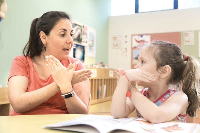A teacher showing sign language to a student