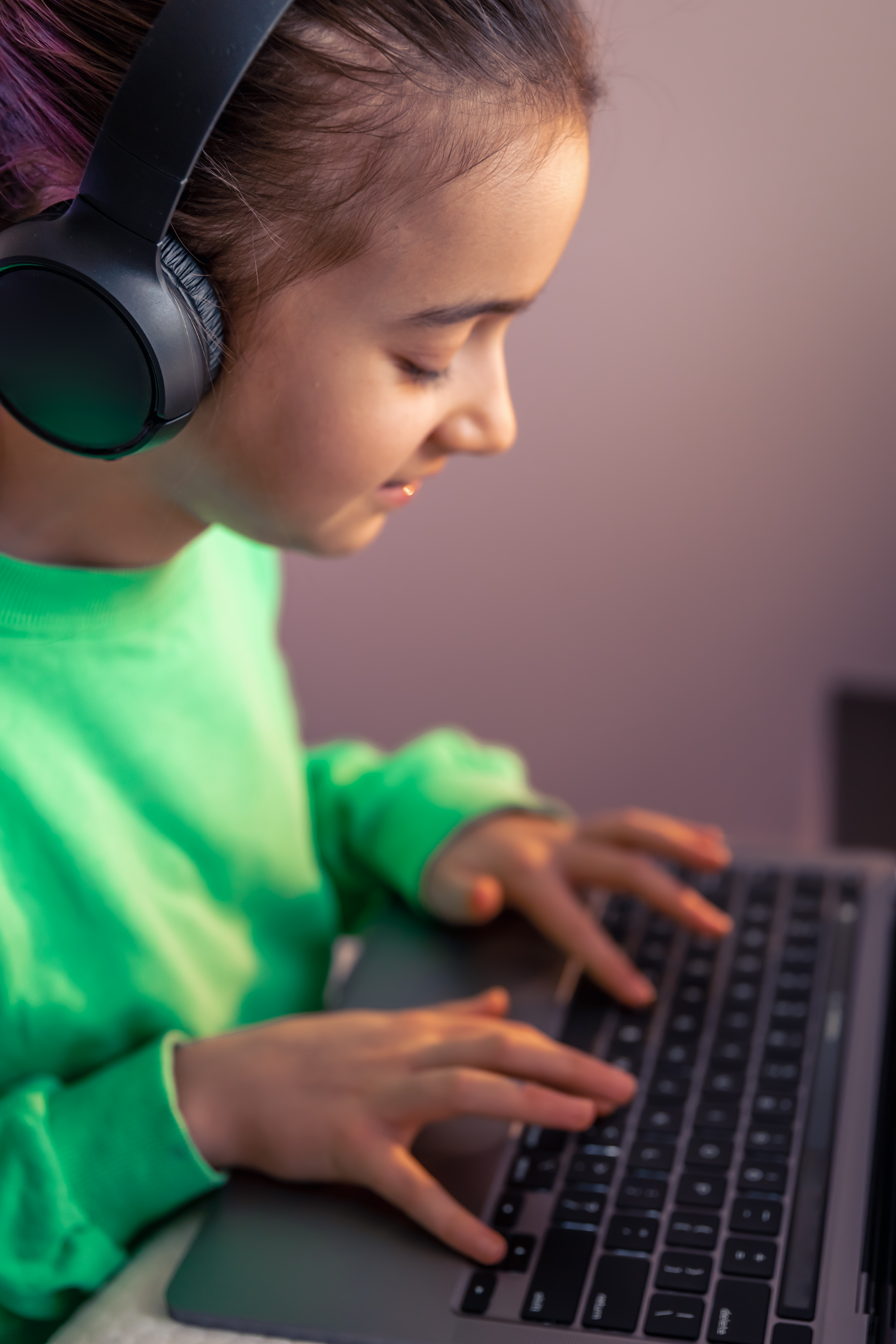 girl using a laptop and wearing headphones