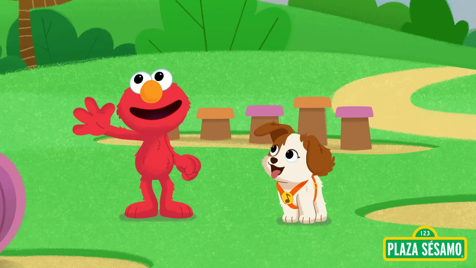 Elmo and Tango in a park, Elmo is raising his hand in a waving gesture while Tango looks at him with a smile.