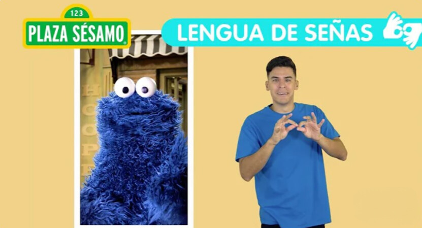 Cookie Monster from Sesame Street is featured, with a man in a blue shirt just out of frame making gestures with his hands. The title reads "Plaza Sésamo Lengua de Señas."