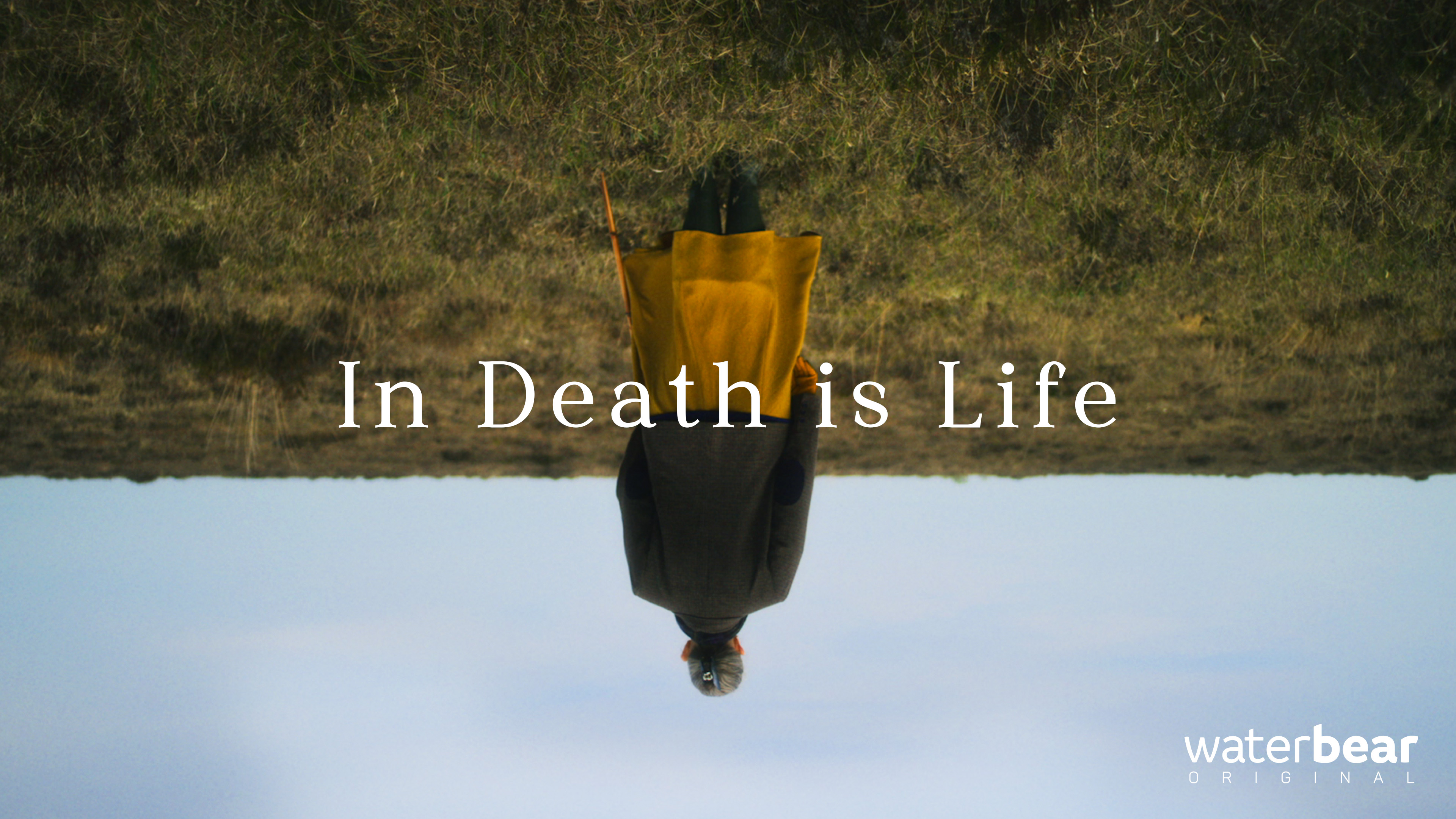 A person stands in a field with their reflection inverted, creating an upside-down effect. The text reads "In Death is Life." Waterbear logo at the bottom right.