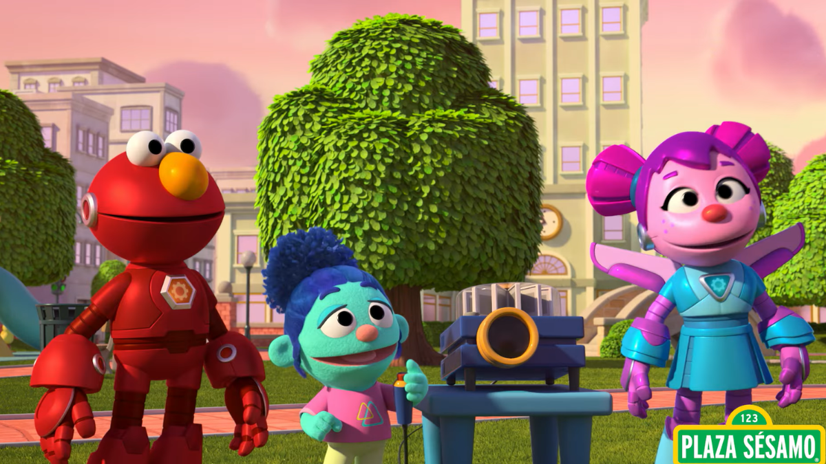 Elmo and Abby, dressed as Meka Builders, stand in a sunny park alongside a cheerful friend, ready for an exciting adventure.