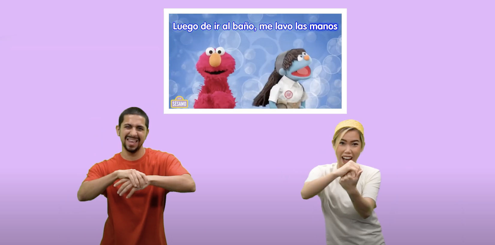 A man and a woman performing American Sign Language for a clip featuring Elmo from Plaza Sésamo, which includes the caption: 'After using the bathroom, wash your hands.